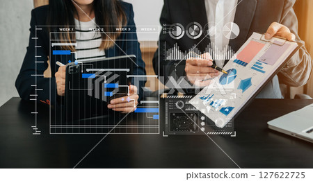 Business team hand Project manager working and update tasks and Gantt chart scheduling virtual diagram.with smart phone, tablet and laptop Business team hand Project manager working and update tasks and Gantt chart scheduling virtual diagram.with smart phone, tablet and laptop 127622725