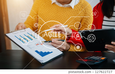 Agile development methodology concept. Business hand using laptop computer and tablet with virtual screen Agile icon on office digital technology concept. Agile development methodology concept. Business hand using laptop computer and tablet with virtual screen Agile icon on office digital technology concept. 127622727