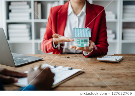 Signing a contract. Client and broker agent, lease agreement, successful deal and Young business sitting at the desk in office Signing a contract. Client and broker agent, lease agreement, successful deal and Young business sitting at the desk in office 127622769
