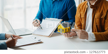 Sales giving male customer signing sales contract, Asian woman and man doing business in office, business concept and contract signing. 127622773