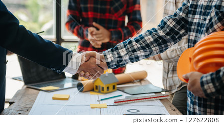 Creative architect projecting on the big drawings in the dark loft office or cafe Creative architect projecting on the big drawings in the dark loft office or cafe 127622808