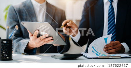Businessman and team analyzing financial statement Finance task. with smart phone and laptop and tablet. Businessman and team analyzing financial statement Finance task. with smart phone and laptop and tablet. 127622817