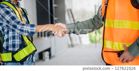 Construction team shake hands greeting start new project plan behind yellow helmet in office center to consults about their building project. Construction team shake hands greeting start new project plan behind yellow helmet in office center to consults about their building project. 127622826
