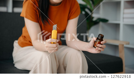 Asian Woman sitting in the sofa with a large number of pills Depressed woman wants to kill herself by drug overdose, depression concept. 127622918