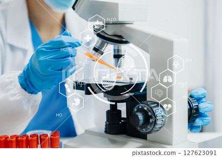 DNA molecule testing concepts. The doctor in a mask examines DNA molecules on the chemical laboratory with virtual icon 127623091