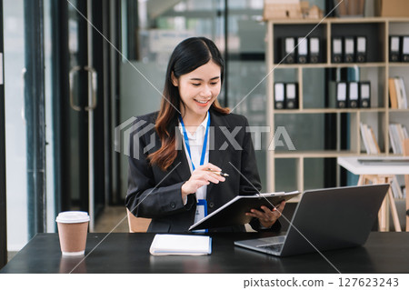 Confident business expert attractive smiling young woman holding digital tablet  on desk in office. 127623243