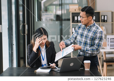 Furious two Asian businesspeople arguing strongly after making a mistake at work in modern office Furious two Asian businesspeople arguing strongly after making a mistake at work in modern office 127623246