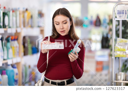 Young woman choosing toothpaste in store 127623317