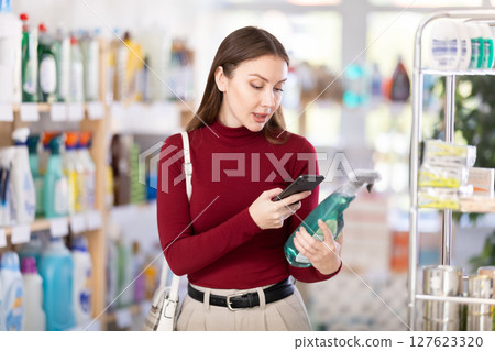 Young woman scanning qr code for cleaning spray 127623320