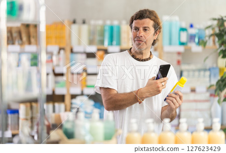 Man scanning mosquito repellent in pharmacy 127623429