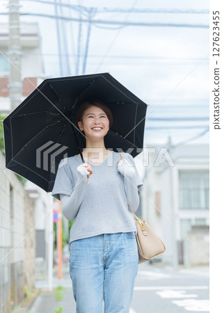 A smiling woman holding a parasol A smiling woman holding a parasol 127623455