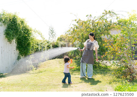 父母和孩子在花園澆水 父母和孩子在花園澆水 127623500