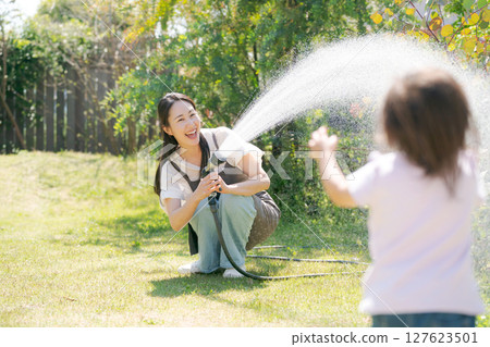 父母和孩子在花園澆水 127623501