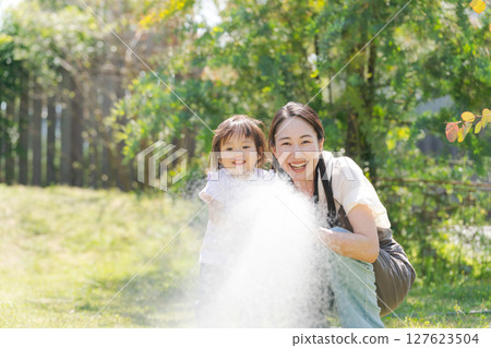 Parents and children watering the garden 127623504