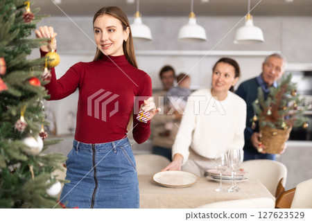 Woman decorating Christmas tree 127623529