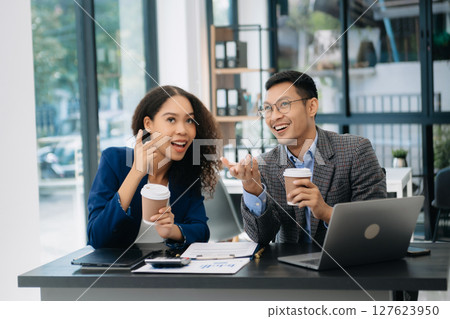 Businesswomen work and discuss their business plans. A Human employee explains and shows her colleague the results paper 127623950