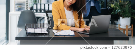 Businesswoman working in the office with working notepad, tablet and laptop documents 127623970