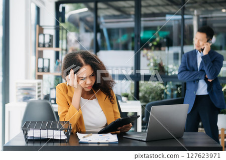 Businesswoman working in the office with working notepad, tablet and laptop documents 127623971