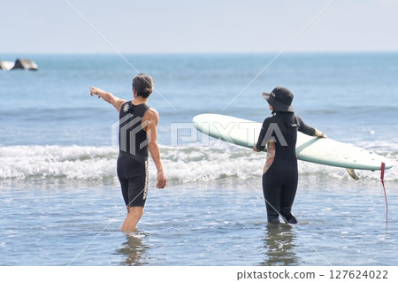 Instructor and woman surfing lesson 127624022