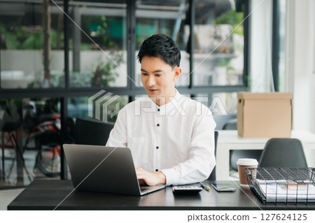 Asian man sitting at a desk using a laptop computer Navigating Finance and Marketing with Technology Asian man sitting at a desk using a laptop computer Navigating Finance and Marketing with Technology 127624125