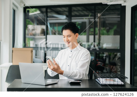 Asian man sitting at a desk using a laptop computer Navigating Finance and Marketing with Technology Asian man sitting at a desk using a laptop computer Navigating Finance and Marketing with Technology 127624126
