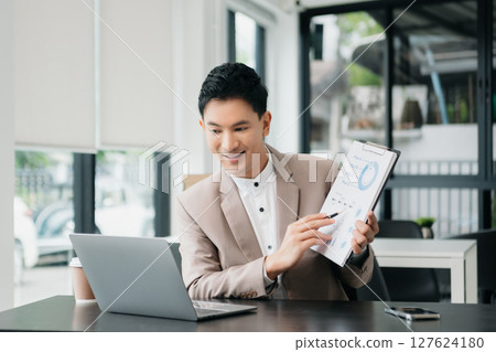 Working man concept a male manager attending video conference and holding tablet, smatrphone in office Working man concept a male manager attending video conference and holding tablet, smatrphone in office 127624180