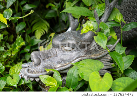 Bronze dragon fountain hidden in greenery on Enoshima Island, Japan 127624472