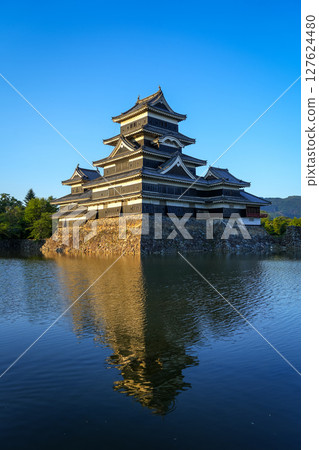 Matsumoto Castle reflecting in the water at sunset, Japan 127624480