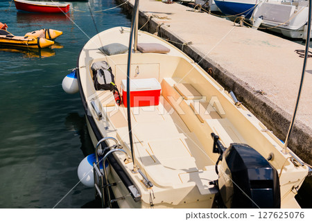 Small boats lined up at marina with modern coastal skyline in the background. Urban tourism, coastal life, and everyday boating in seaside European towns. Small boats lined up at marina with modern coastal skyline in the background. Urban tourism, coastal life, and everyday boating in seaside European towns. 127625076