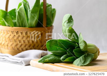 Organic Bok choy or Pak choi on cutting wooden board and basket, Fresh vegetable, Food ingredient 127625470