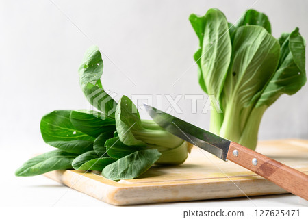 Organic Bok choy or Pak choi on cutting wooden board with kitchen knife, Fresh vegetable 127625471