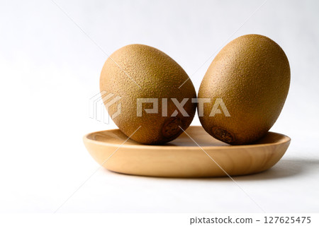 Fresh kiwi fruit on wooden plate with white background, Healthy fruit Fresh kiwi fruit on wooden plate with white background, Healthy fruit 127625475