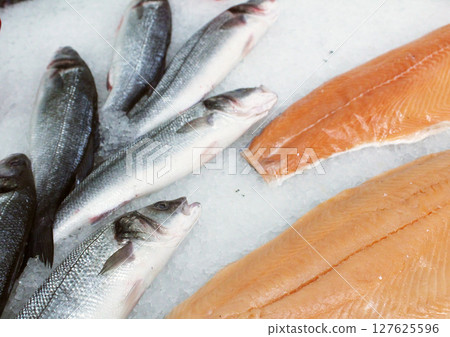 Sea bream fish and red fish lie on snow and ice. Sale of chilled fish Sea bream fish and red fish lie on snow and ice. Sale of chilled fish 127625596