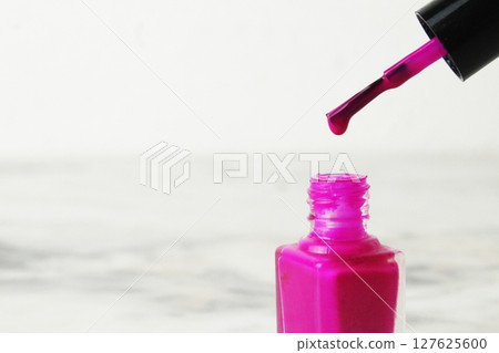 A drop of nail polish dripping from a brush close-up on a white background with space for copyspace text 127625600