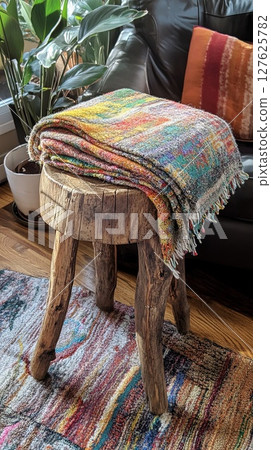 wooden stool with work-in-progress blanket. 127625782
