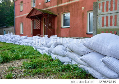 Sandbags stacked near house to protect from flood risk emergency 127625849