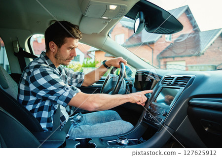 Man pressing car engine start button inside vehicle 127625912