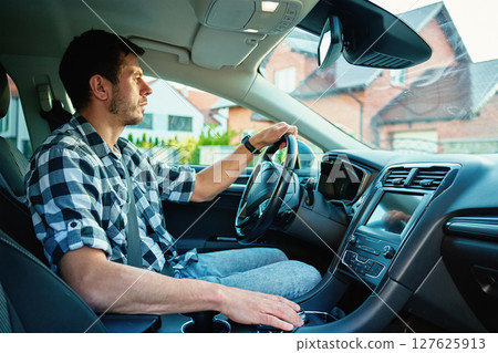 Focused man driving car, interior view 127625913