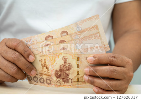 Asian woman holding Thai banknotes money, economy finance exchange trade investment. Asian woman holding Thai banknotes money, economy finance exchange trade investment. 127626317