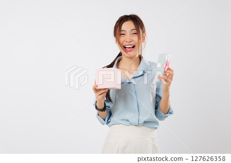 Gift box opened with bright big smile by Asian woman celebrating special day, enjoying the excitement of receiving another thoughtful pink gift from someone she loves. isolated studio white background 127626358