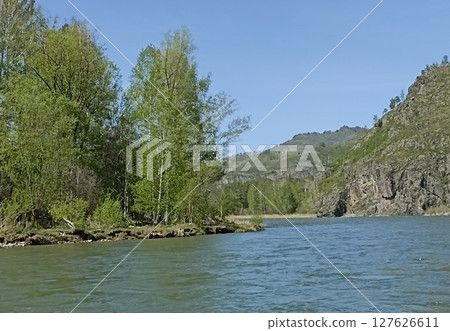 Idyllic River Scenery Verdant Forest Meets the Calm Waters of a Serene River Landscape. Idyllic River Scenery Verdant Forest Meets the Calm Waters of a Serene River Landscape. 127626611