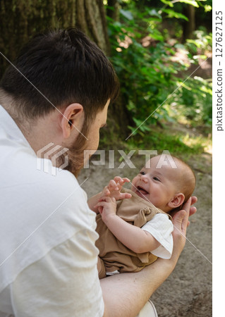 Father Holding Baby in Sunny Park 127627125