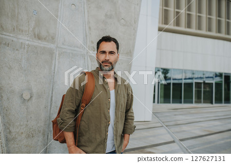 Confident middle-aged male standing casually in urban setting 127627131