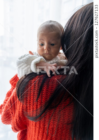 Tender Moment Between Mother and Baby by the Window 127627133