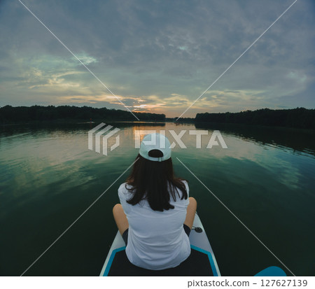 Paddleboarding at Sunset on a Calm Lake Paddleboarding at Sunset on a Calm Lake 127627139