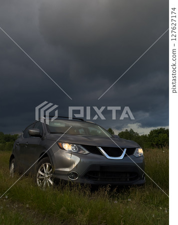 SUV in a Field Under Dramatic Skies 127627174