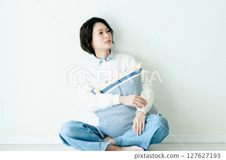 坐在牆前的年輕女子 127627193