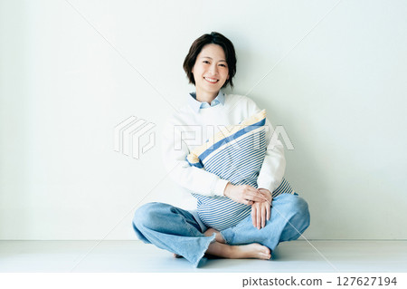 坐在牆前的年輕女子 127627194