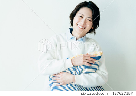 Young woman sitting in front of a wall Young woman sitting in front of a wall 127627197