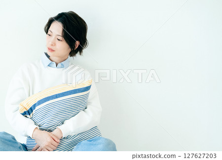 坐在牆前的年輕女子 127627203